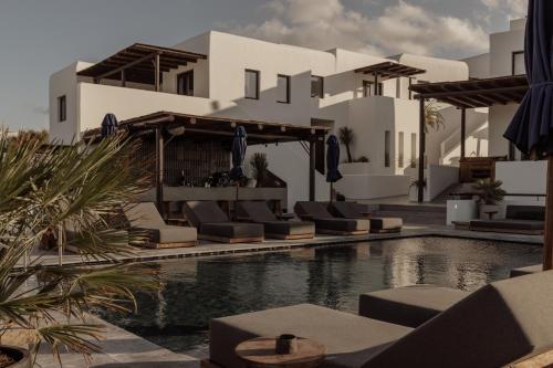 奥诺斯Casa Cook Mykonos - Adults Only的一个带游泳池和椅子的度假胜地和一座建筑