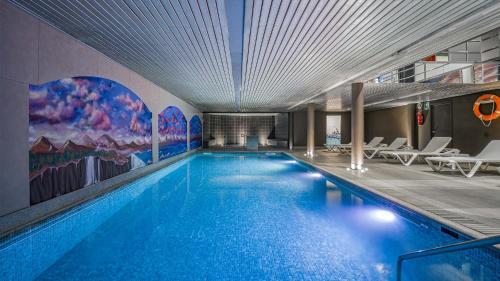 安道尔城Roc Blanc Hotel & Spa的大楼内一个蓝色的大型游泳池