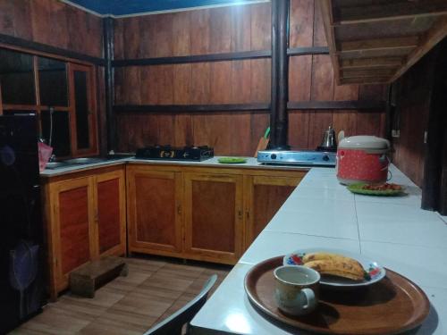 BajawaHome stay wolokoro ecotourism的厨房在柜台上放有盘子的食物