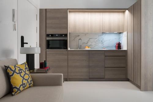马德里Apartamentos Las Torres的厨房配有木制橱柜和沙发。