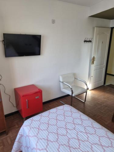洛马斯-德萨莫拉GORRITI VIEW的客房设有床、椅子和平面电视。