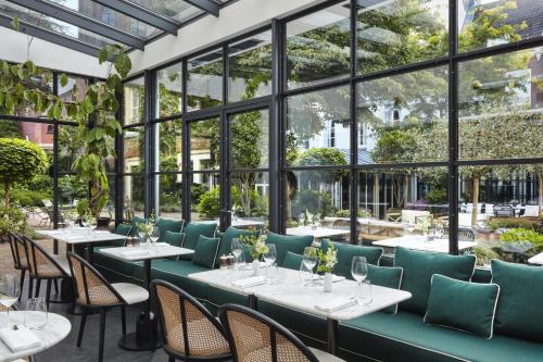 阿姆斯特丹阿姆斯特丹普利策酒店的餐厅设有桌椅和窗户。