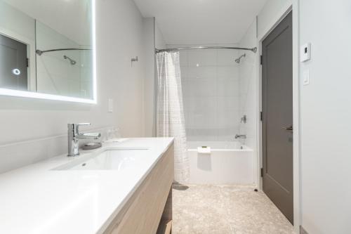 蒙特朗布朗Suites du Lac Moore的白色的浴室设有水槽和淋浴。