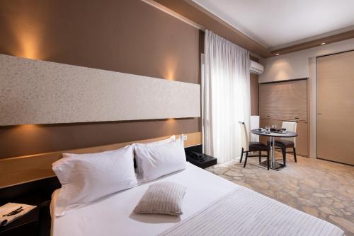 波托什Afrodite Suites的酒店客房配有一张床铺和一张桌子。