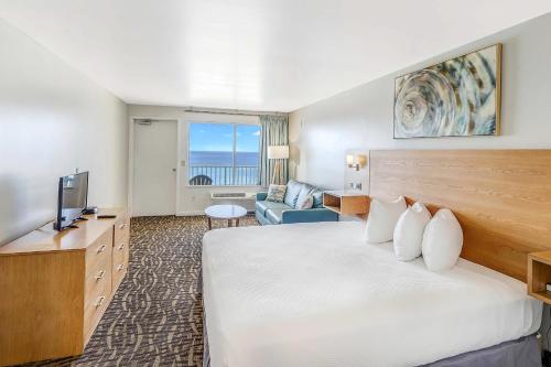 巴拿马城海滩Beach Tower Beachfront Hotel, a By The Sea Resort的酒店客房设有一张大床和一台电视。