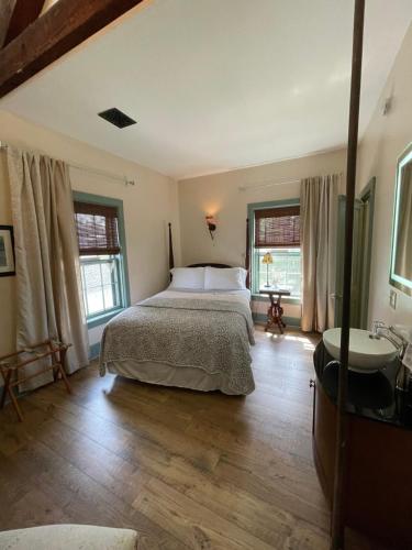 威诺纳Carriage House Bed & Breakfast的一间卧室配有床、水槽和窗户