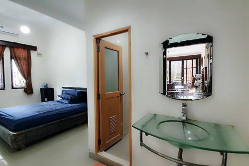 TanjungkarangVilla 5 BR utk Family/Grup di Villa Citra, Lampung的一间卧室配有玻璃桌、一张床和镜子