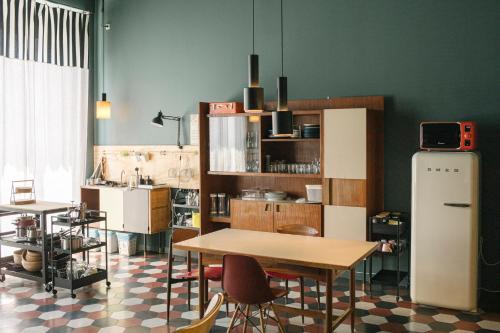 米兰卡萨贝斯青旅的厨房配有桌椅和冰箱。