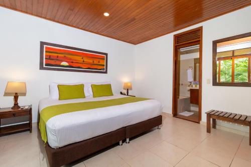比亚维森西奥Hotel Campestre La Potra的一间带大床的卧室和一间浴室