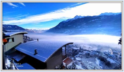 奥斯塔Atmosfera e vista mozzafiato Chalets的雪中城市与山脉的景色
