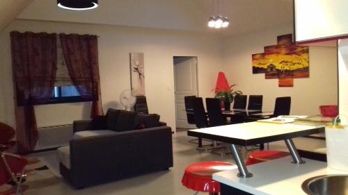 格朗维尔Les granvillaises的客厅配有沙发和桌椅