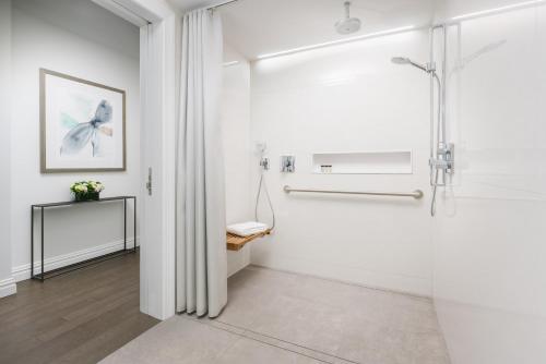 纽约The Wallace Hotel的浴室拥有白色的墙壁和淋浴间。