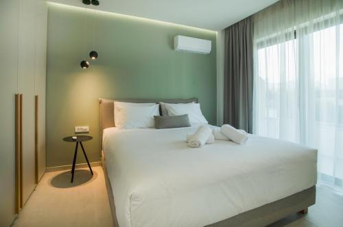 阿基欧斯尼古拉斯Celine Luxury Apartments & Suites的卧室配有一张大白色床和窗户