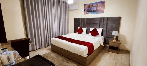 安曼Golden Hotel的一间卧室配有一张带红色枕头的大床