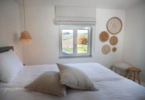 埃彭Vakantiewoningen Liefst in Epen的卧室内的白色床和窗户