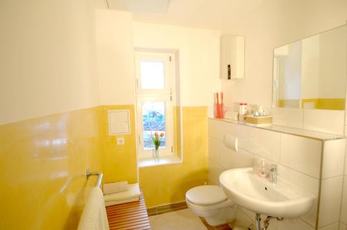 柏林斯塔维拉公寓的一间带水槽和卫生间的浴室以及窗户。