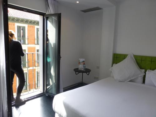 马德里梅耶林酒店的一个人在看卧室的窗户