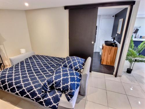 Saint-Aignan-Grand-LieuLe Petit Rocher 30m2- Studio standing tout confort的卧室配有蓝色和白色的被子。