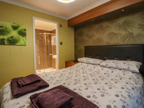 哈罗盖特Swinsty Lodge的一间卧室配有一张床,上面有两条毛巾