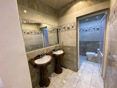 欧拉Almazham holiday house的一间带两个盥洗盆、淋浴和卫生间的浴室