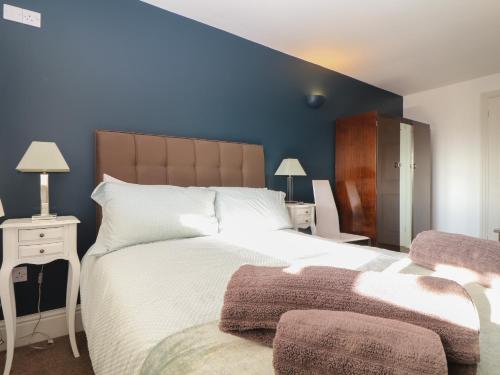 雷德鲁斯Fern Cottage的一间卧室设有一张大床和蓝色的墙壁