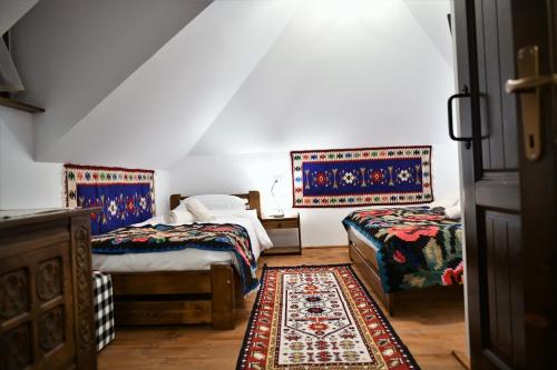 SăcelCasuta din Cotroape的一间带两张床的卧室和地毯