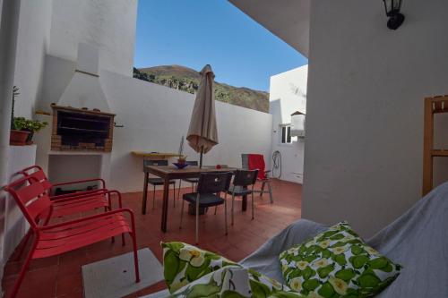 塔马达斯特Mar y Sol Casa Con Terraza y Barbacoa A 10 Metros del Mar的客厅配有桌椅和遮阳伞
