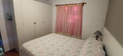 杜拉斯诺El Remanso的一间小卧室,配有一张床和粉红色窗帘