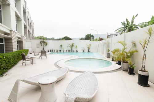 安蒂波洛LeBlanc Hotel的庭院设有游泳池、椅子和桌子。