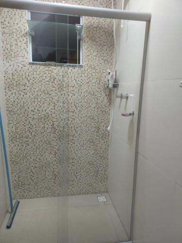 圣洛伦索Casa em São Lourenço-MG的浴室里设有玻璃门淋浴