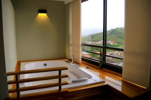 AguadasHotel Entre Brumas的设有一个大浴缸的大窗户