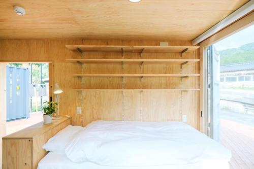 Nishiawakura安全第一客室 Anzen Daiichi INN的木墙客房的一张床位
