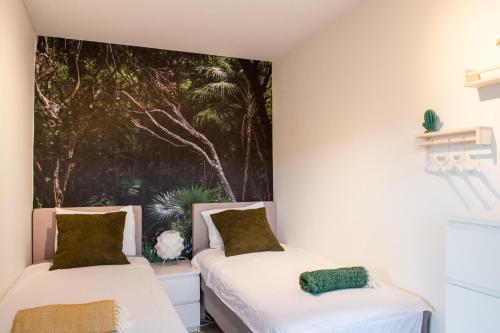 Dorp Sint MichielBlue Bay Resort luxury apartment Green View的墙上画画的房间里设有两张床
