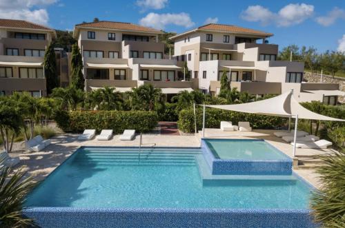 Dorp Sint MichielBlue Bay Resort luxury apartment Green View的大楼前的游泳池