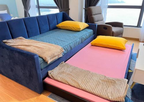 关丹Comfy Imperium Residence Kuantan Studio Seaview的蓝色的沙发,带两个垫子和两个垫子