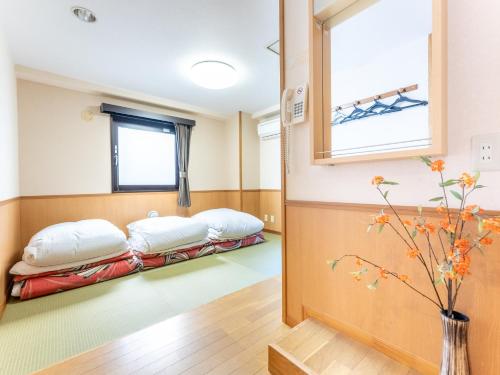 东京Chang Tee Hotel Ikebukuro的一间医院的两张床,设有窗户
