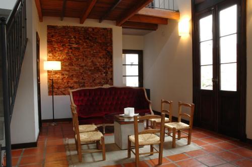 布宜诺斯艾利斯波萨达高登酒店的客厅配有红色的沙发、桌子和椅子