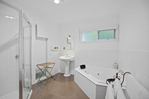 马里斯维尔阿梅丽娜别墅的白色的浴室设有浴缸和水槽。