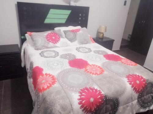 特鲁希略Apartamento familiar的一间卧室,床上有粉红色的鲜花