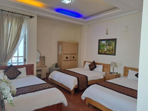 大叻大叻蒂布旅馆的酒店客房设有三张床和蓝色天花板。