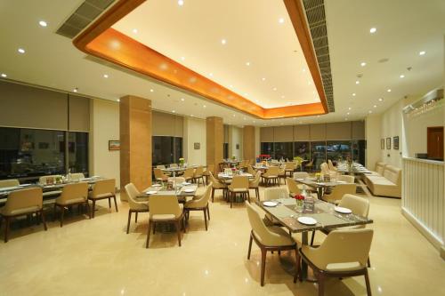 乌代浦Pride Hotel Udaipur的一间在房间内配有桌椅的餐厅