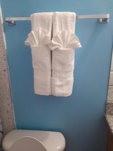 拉纳韦贝HARMONY LA VISTA的浴室内架上悬挂着一组白色毛巾