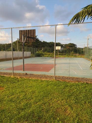 拉纳韦贝HARMONY LA VISTA的一个带围栏和篮球架的网球场