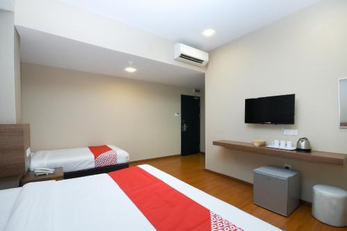 米里Super OYO 977 Hong Kong Suites的酒店客房设有两张床和一台平面电视。