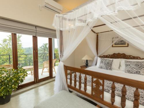 康提Edgar Mansion Kandy的一间卧室设有一张天蓬床和一个阳台