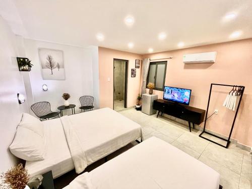 芹苴MIDMOST Boutique Hostel的大型客房配有床和电视。