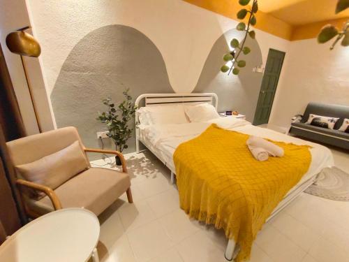 古来Kulai Dream Homestay 4room 16pax @near Kulai Aeon, JPO, Senai Airport, Legoland的一间卧室配有一张带黄毯和椅子的床