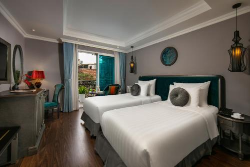 河内Hanoi L'Heritage Hotel & Gym - Spa的酒店客房设有两张床和窗户。