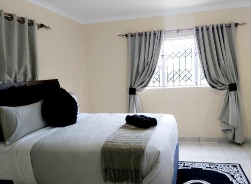 InandaEzweni Lodge的一间卧室设有一张大床和一个窗户。
