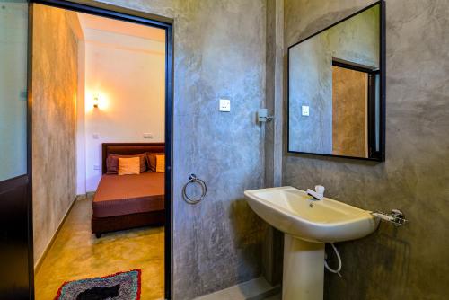 韦利格默2b1 weligama的一间带水槽和镜子的浴室以及一张床